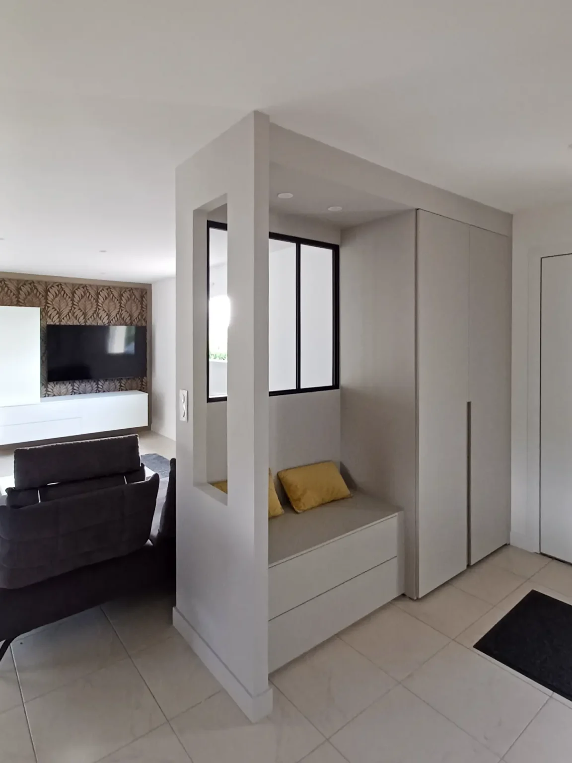 Entrée aménagée sur-mesure : banquette à tiroirs et grand placard encadrés d'une cloison à verrière